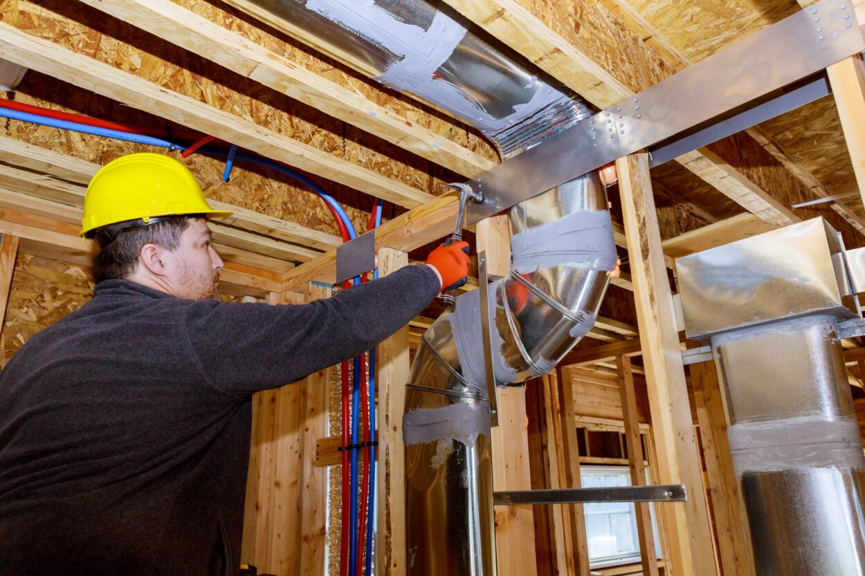 Worker checking on air duct