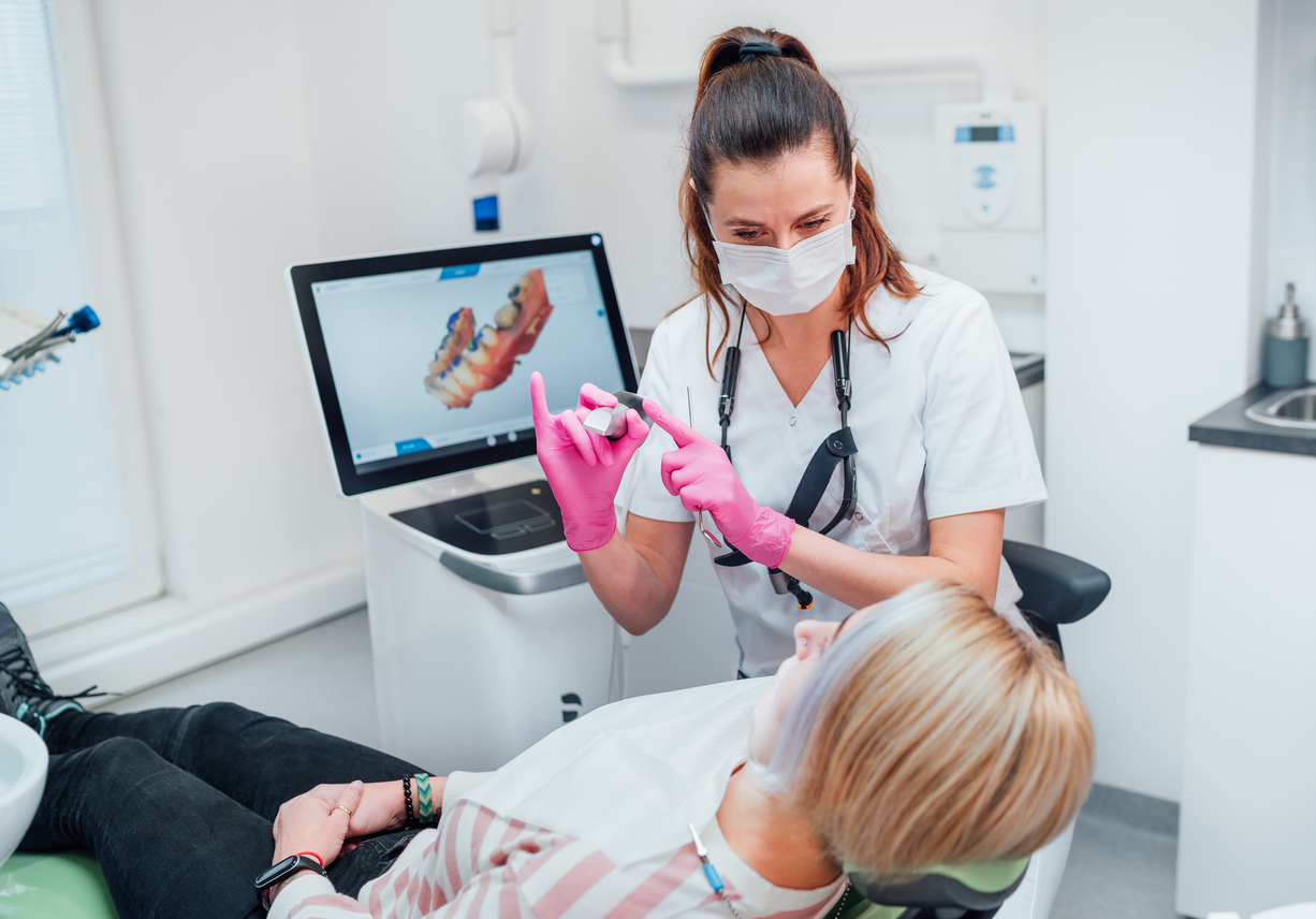 Dentist in uniform using intraoral 3D dental scanner Machine for clear aligners production. Dental clinic patient visit modern medical ward. Health teeth care, medicare industry concept.